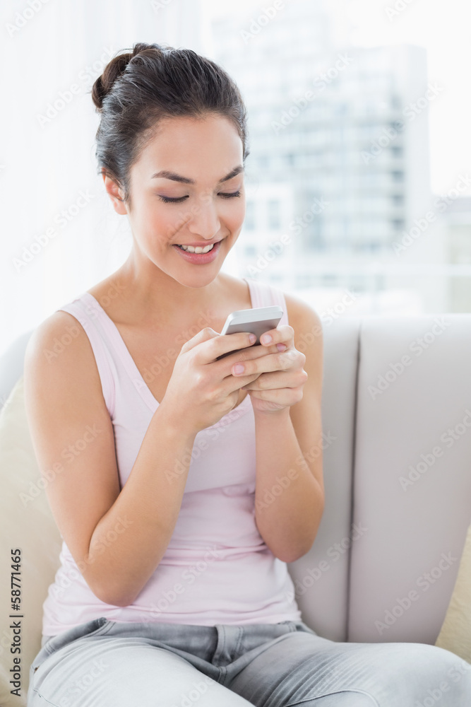 Relaxed woman text messaging on sofa at home Relaxed woman text messaging on sofa at home