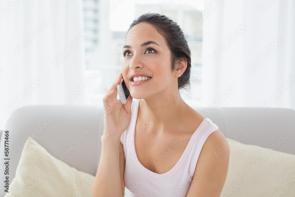 Woman using cellphone on sofa in living room Woman using cellphone on sofa in living room
