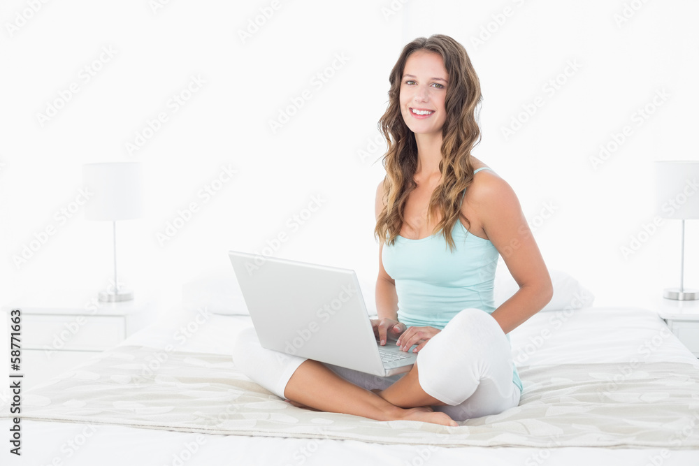 Relaxed young woman using laptop in bed Relaxed young woman using laptop in bed