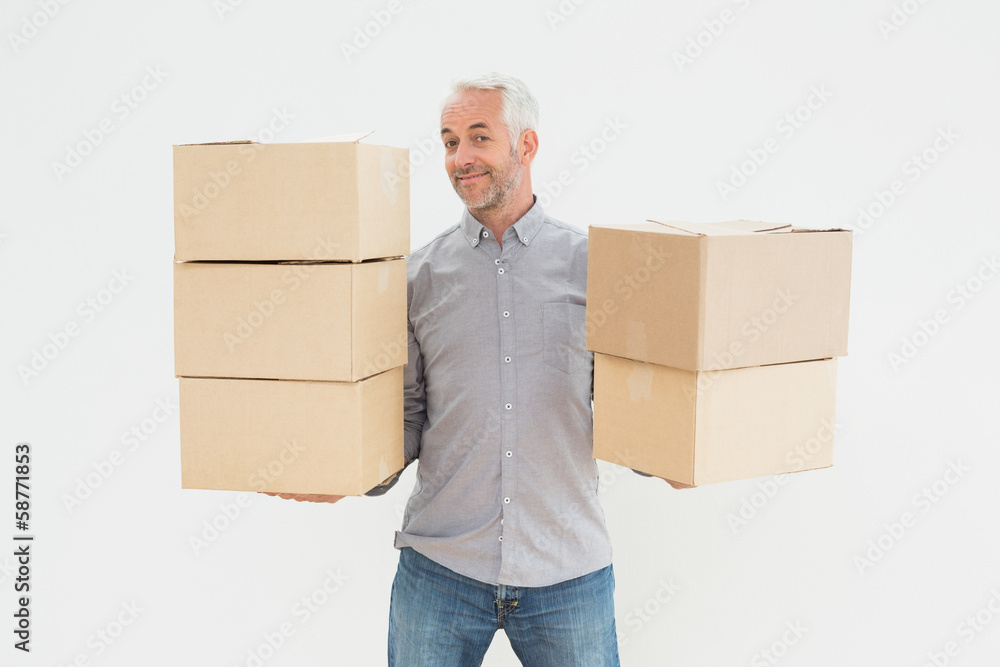 Portrait of a smiling mature man carrying boxes Portrait of a smiling mature man carrying boxes