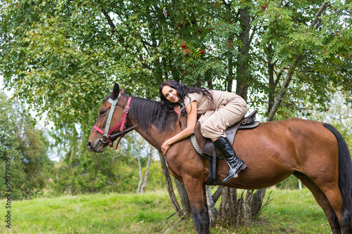 Elegant attractive woman riding a horse