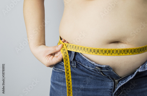 obese woman measuring her waist