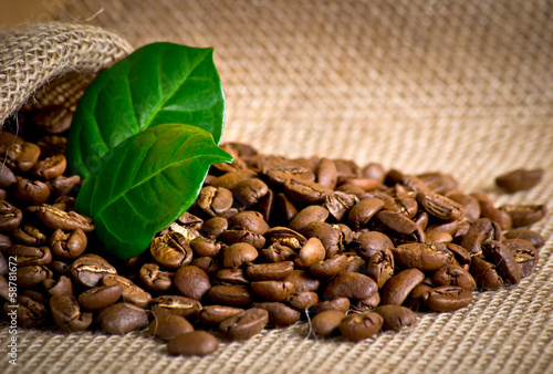 Coffee grains with bag and leaves on sackcloth