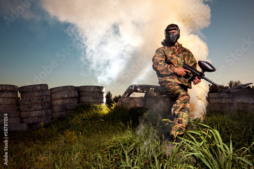 Paintball player holding the position with smoke background