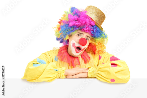 Male circus clown making a grimace on a blank panel