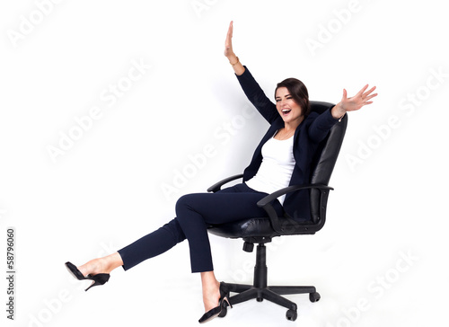 Happy successful business woman in office chair