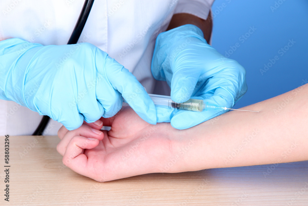 vaccine injection in hand on blue background vaccine injection in hand on blue background