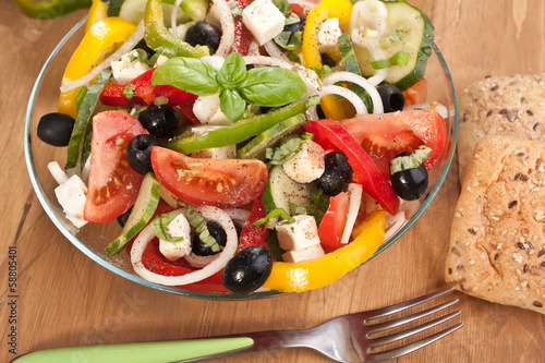Bowl of healthy greek salad with lettuce  tomatoes  onion bell peppers  black olives and feta cheese