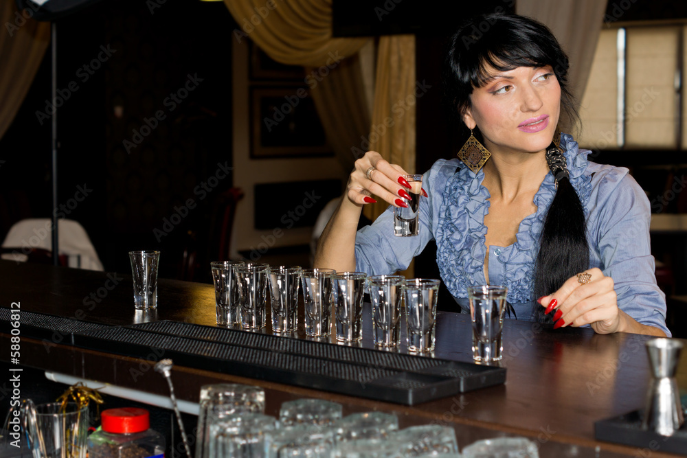 Woman drinking vodka shots at a bar