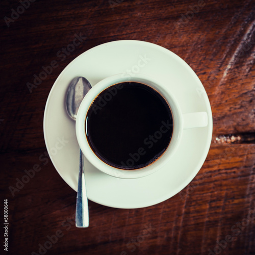 Black coffee in white cup on wooden