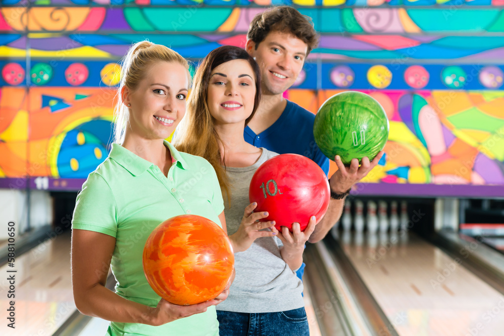 Fototapeta premium Young people playing bowling and having fun