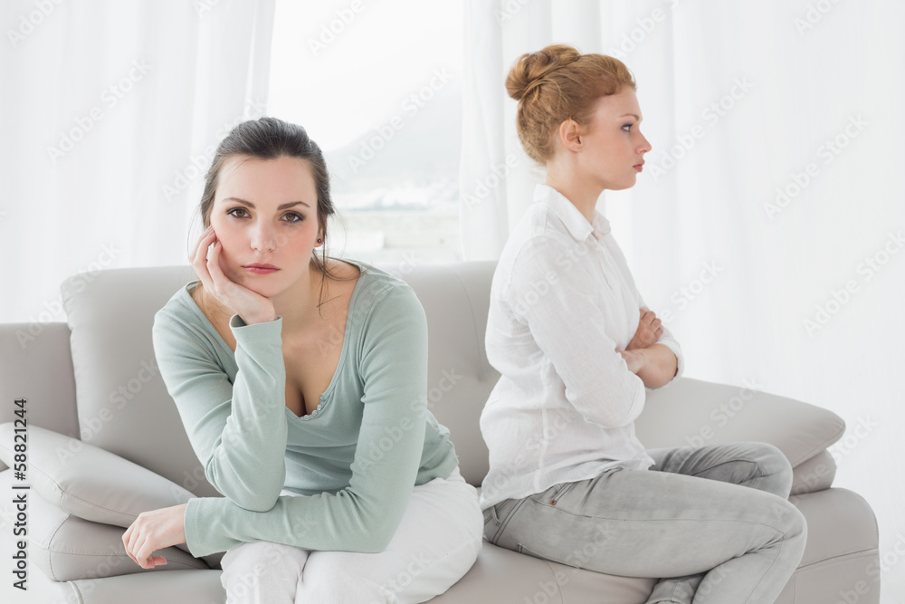 Unhappy friends not talking after argument on the couch Unhappy friends not talking after argument on the couch