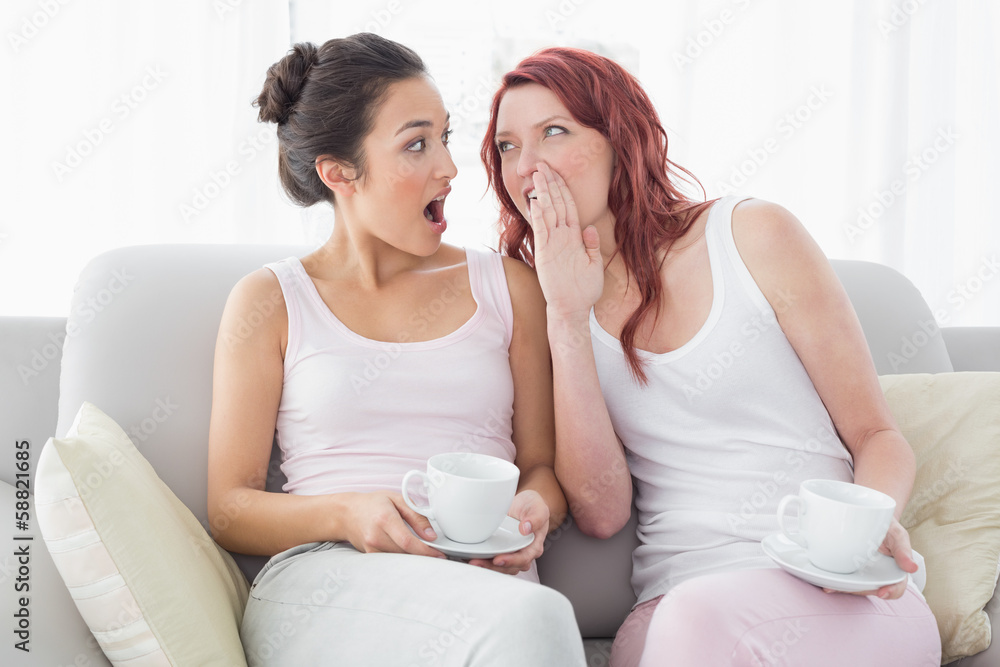 Friends with coffee cups gossiping in the living room