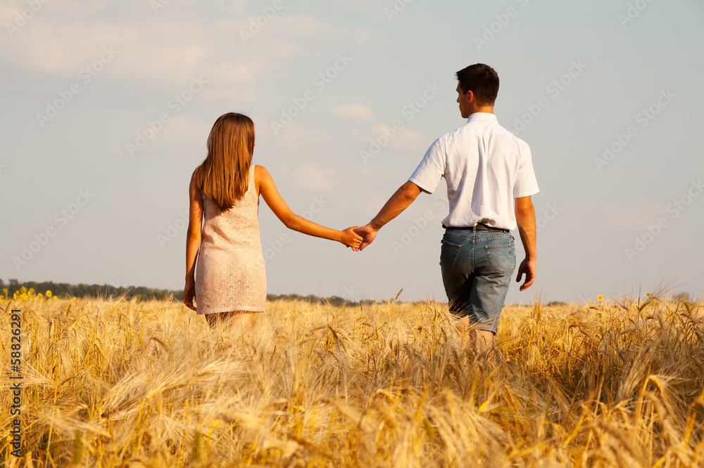 inlove couple walking through  wheat field