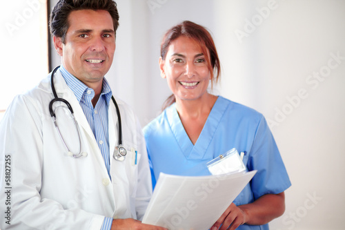 Medical couple smiling and looking at you