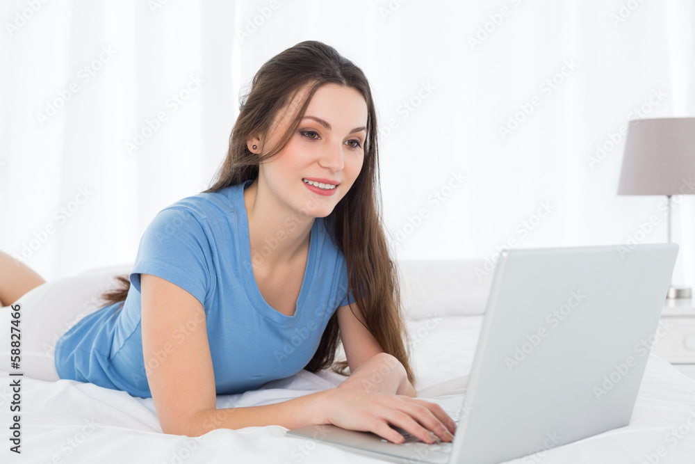Beautiful woman using laptop in bed Beautiful woman using laptop in bed