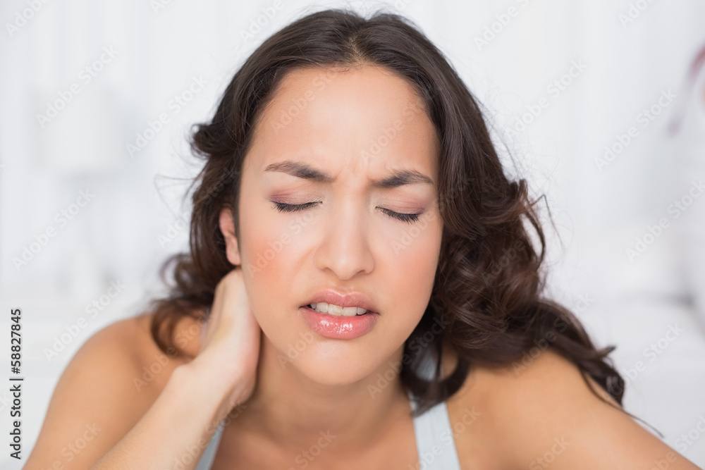 Woman suffering from neck pain with eyes closed Woman suffering from neck pain with eyes closed
