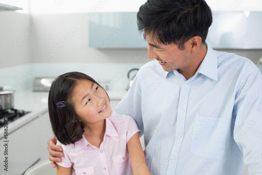 Smiling father and young daughter in kitchen Smiling father and young daughter in kitchen