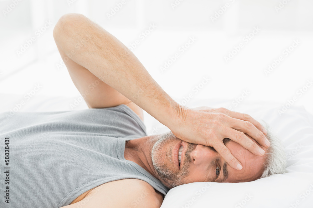 Smiling mature man resting in bed Smiling mature man resting in bed