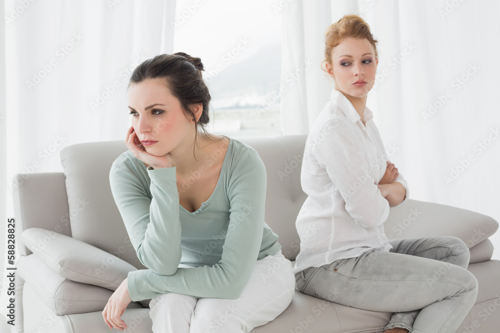 Unhappy friends not talking after argument on the couch Unhappy friends not talking after argument on the couch