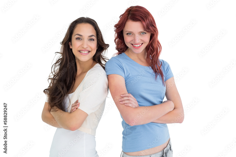 Portrait of two female friends standing with arms crossed Portrait of two female friends standing with arms crossed