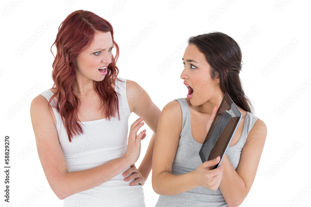 Two shocked young female friends with digital tablet Two shocked young female friends with digital tablet