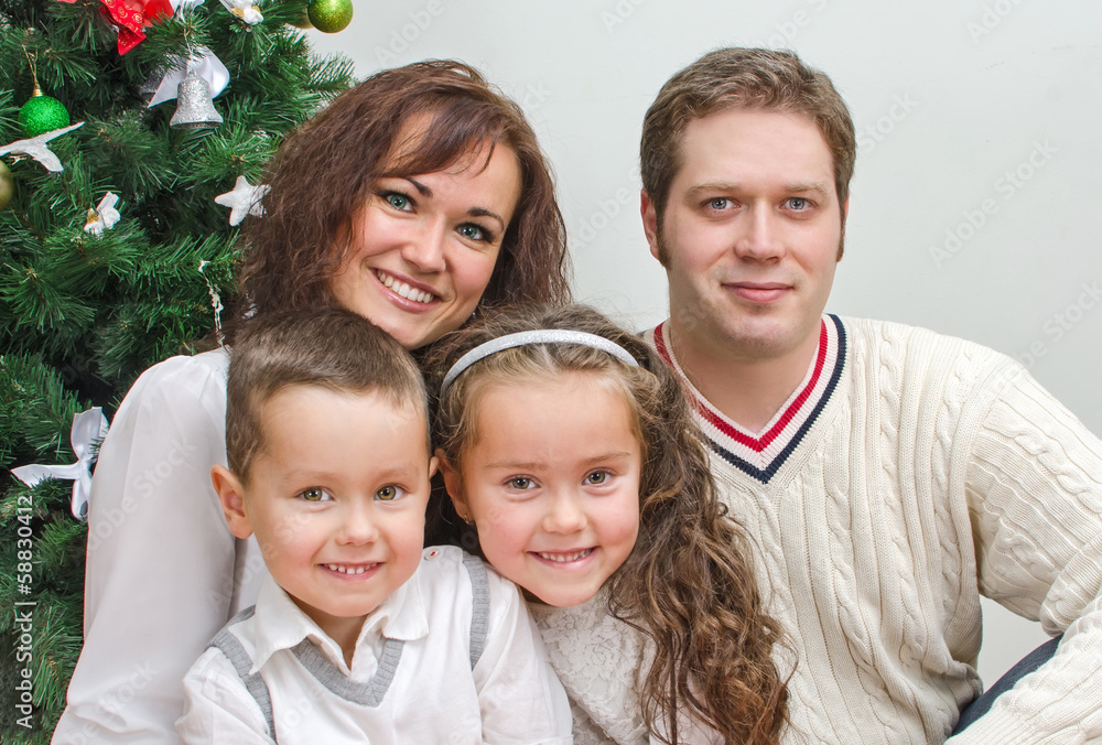 Happy family members sitting over christmas tree Happy family members sitting over christmas tree