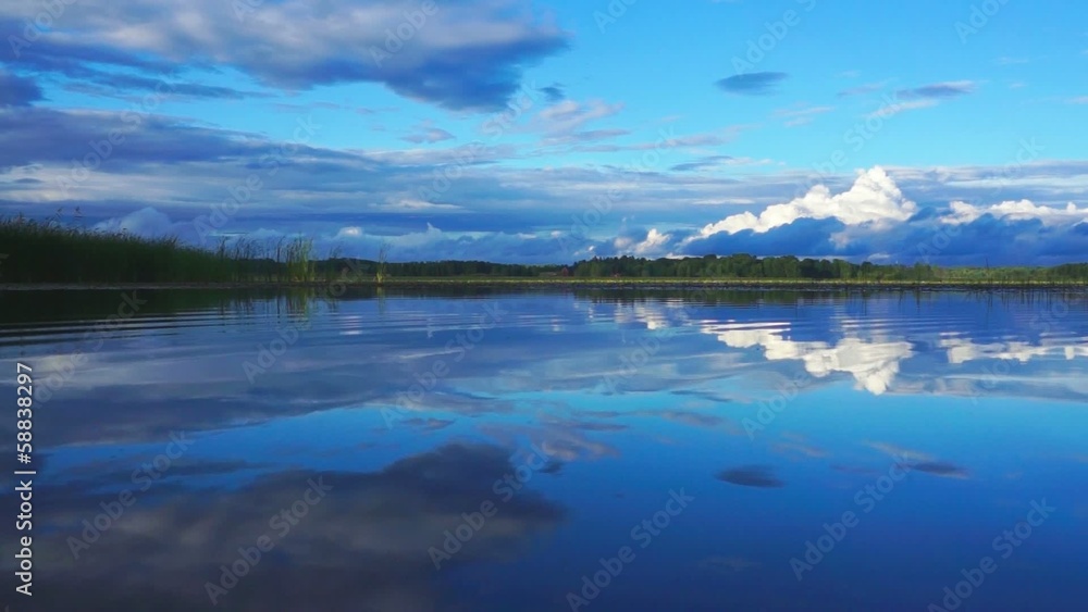 White fluffy clouds reflected in water White fluffy clouds reflected in water