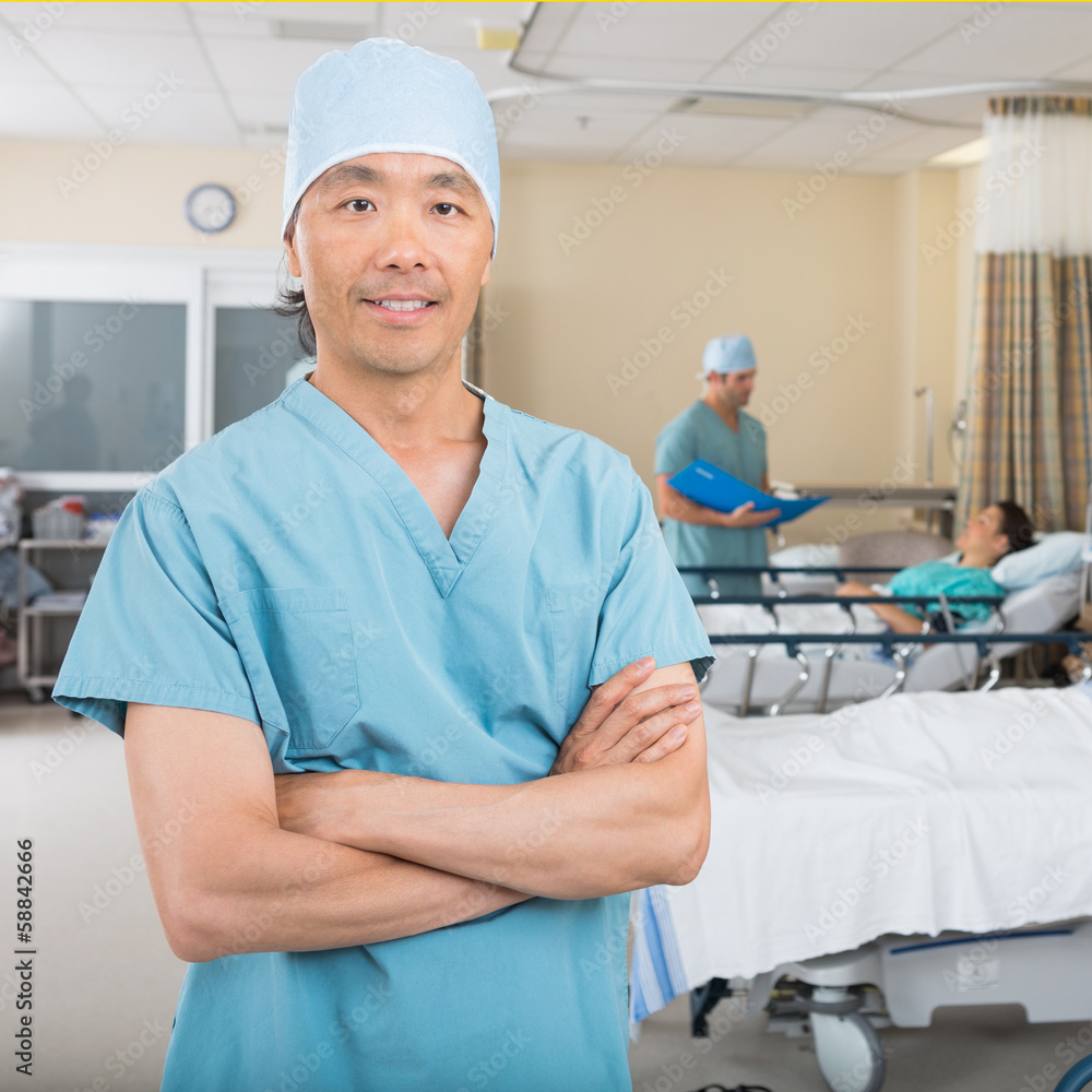 Male Nurse Standing In Hospital Ward Male Nurse Standing In Hospital Ward