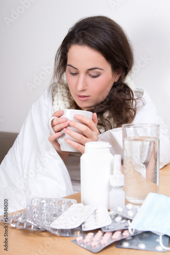 ill woman drinking tea in her living room
