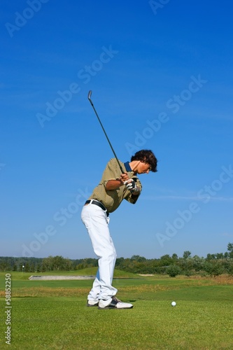 Golf, golfer striking the ball