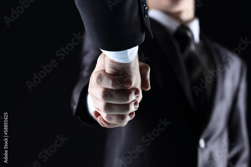 Handshake - Hand holding on dark background