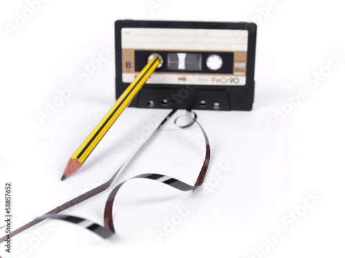 Fotografie retro cassette with loose tape over a white background