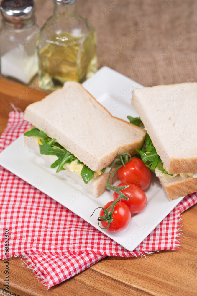 Fresh egg and rocket on white sandwich in rustic kitchen setting Fresh egg and rocket on white sandwich in rustic kitchen setting