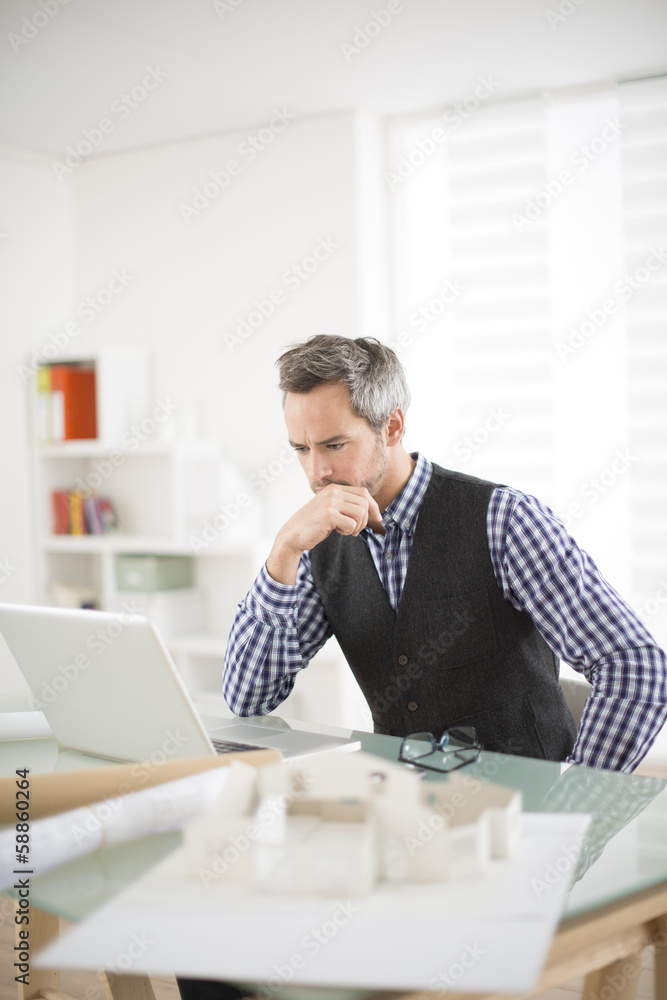 Naklejka premium Architect working at his laptop on the office