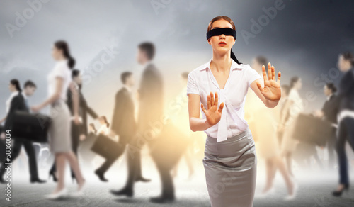 Businesswoman in blindfold among group of people photo