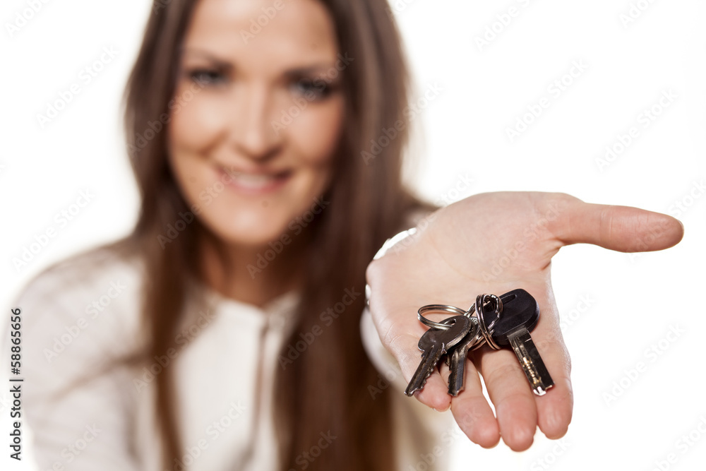 smiling young woman holding in her hand a bunch of keys