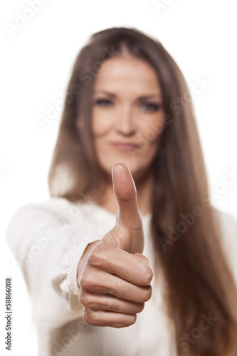 smiling young woman showing thumb up