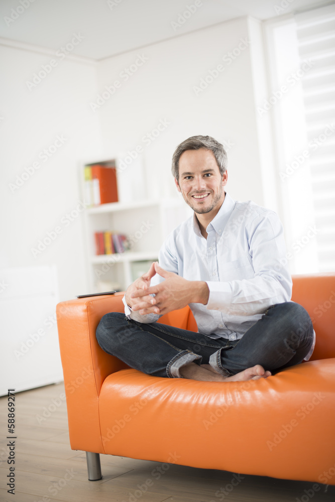 attractive man smiling on a couch attractive man smiling on a couch