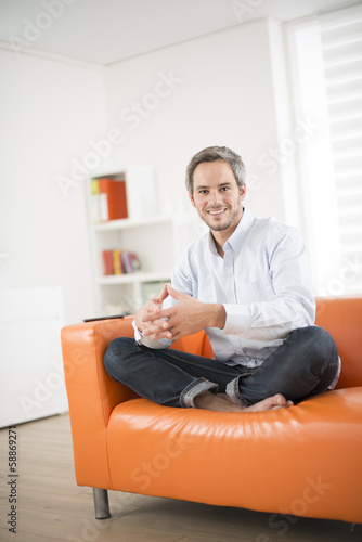 attractive man smiling on a couch