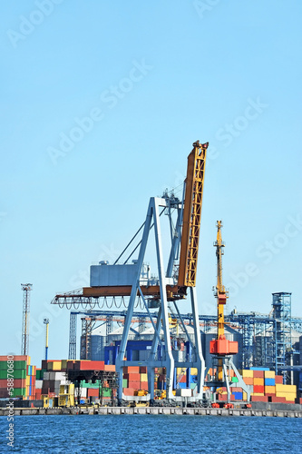 Port cargo crane and container over blue sky background