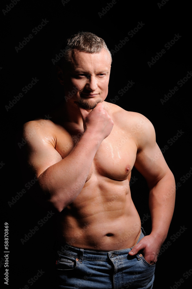 Fototapeta premium Muscular male posing on black background