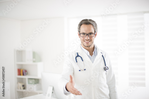 young doctor welcoming at his office