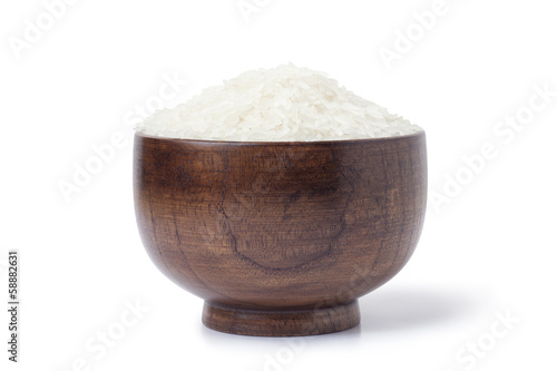 Dry uncooked rice in wooden bowl