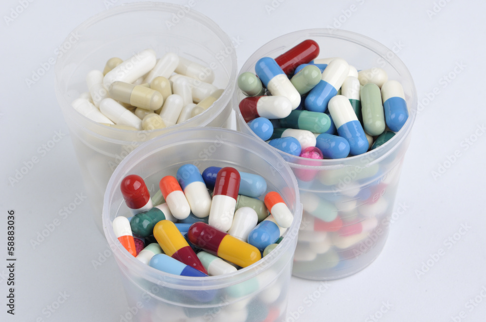 assortment of pills, capsules and tablets variety in plastic pot assortment of pills, capsules and tablets variety in plastic pot