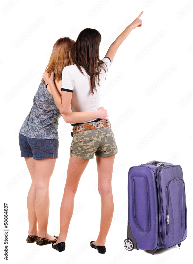 Two young women traveling with suitcas rear view. Two young women traveling with suitcas rear view.