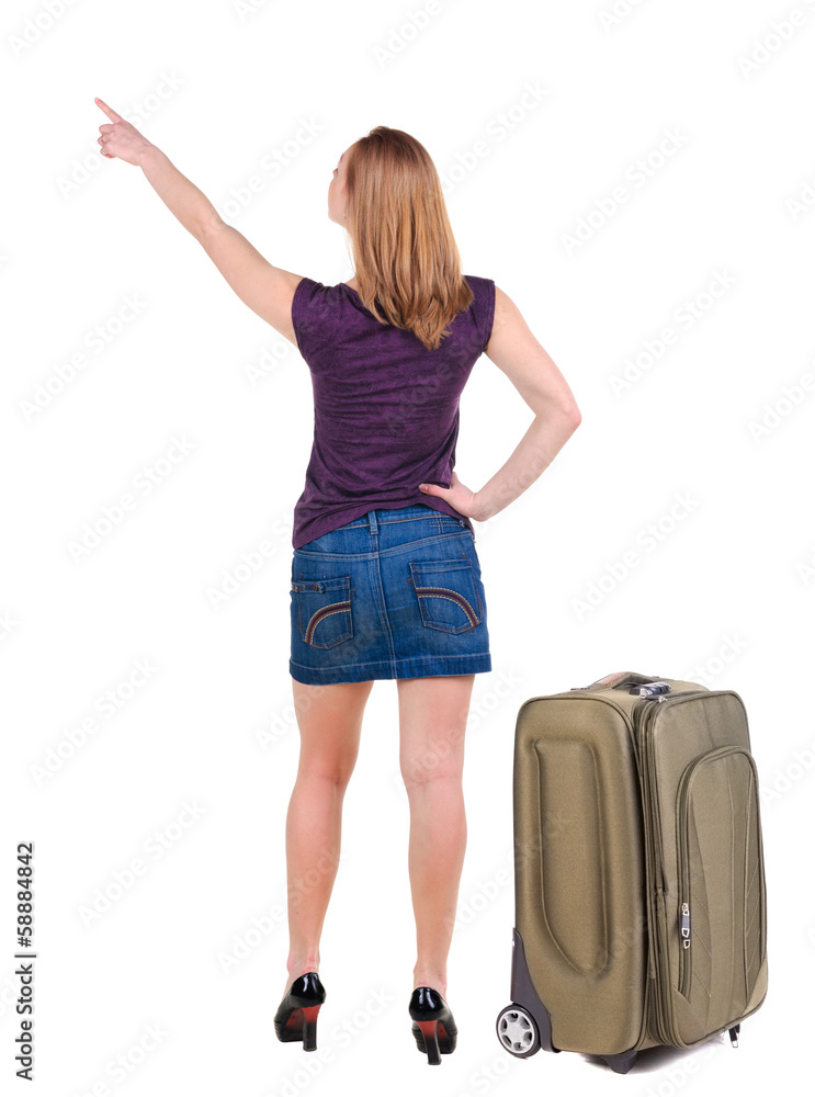 Beautiful young woman in dress traveling with suitcas and point Beautiful young woman in dress traveling with suitcas and point
