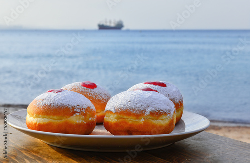 Festive donuts with jam on background of the red Sea photo