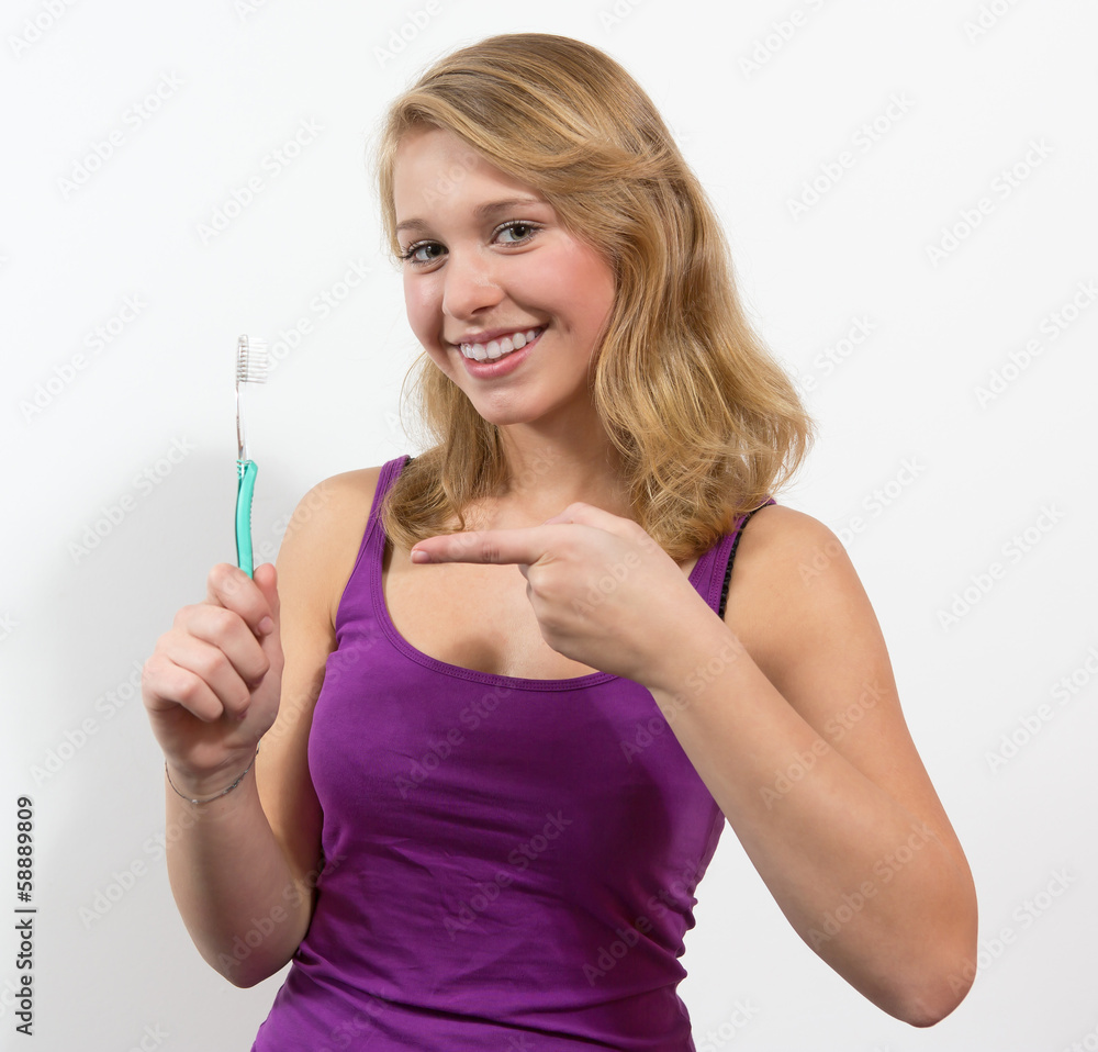 Jugendliche hält lächelnd eine Zahnbürste Jugendliche hält lächelnd eine Zahnbürste