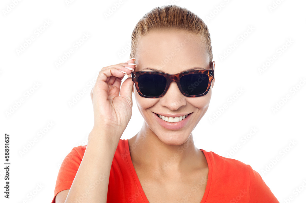 Trendy woman adjusting her sunglasses
